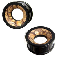 Cargar imagen en el visor de la galería, A pair of black circular Holztunnel Eisenholz plugs with open centers, featuring a hand-carved brown patterned Antikholzinlay inspired by Tribal Holz Tunnel designs.
