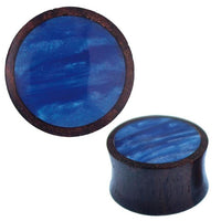 Load image into Gallery viewer, Two Holz Plug Sonoholz blau schillernd Resin Inlay plugs are shown: one displays the glossy blue resin top from above, while the other is angled to highlight its curved wooden side and shimmering inlay.
