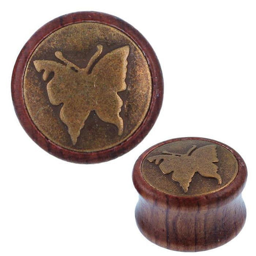 The Holz Plug Schmetterling is a round tribal tunnel expander with an antique golden brass butterfly inlay on its flat face.