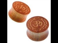 Cargar imagen en el visor de la galería, Two brown wood grain plugs named &quot;Holz braun gemasert Plug Om Blume,&quot; gold-painted with laser-engraved Om inside a lotus flower, are shown on a white background.
