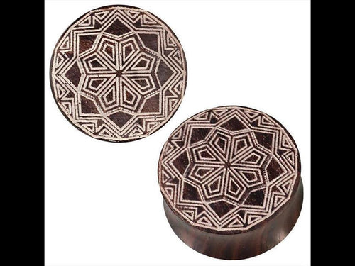 Two Brauner Holz Plugs with white tribal star Zacken gravur, featuring intricate geometric patterns, displayed against a white background.