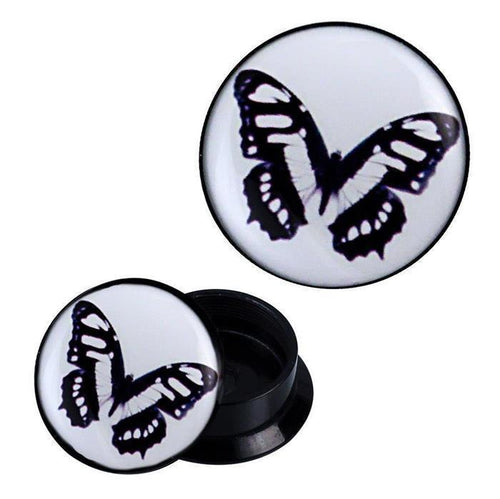 A pair of Schraub Plug Acryl Schmetterling schwarz weiß blau Piercing Ohrschmuck with black circular sides and white faces, each displaying a delicate black, white, and blue butterfly pattern. One plug stands upright, the other lies on its side.