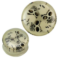 Cargar imagen en el visor de la galería, A transparent acrylic plug featuring three black and white 3D Totenkopf skulls, glowing in the dark. The floating skull design creates a striking effect for piercing and ear jewelry enthusiasts.

