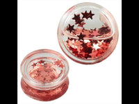 Load image into Gallery viewer, Two small Plug Acryl transparent Flüssigkeit rosa mini Sterne Piercing Ohrschmuck containers are filled with shiny, metallic pink star confetti, some scattered on the lid for a sparkling rosa Stern Effekt.

