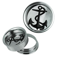 Cargar imagen en el visor de la galería, The Schraub Plug Tunnel silbern schwarz Edelstahl Anker Seil Piercing includes two round silver plugs with black anchor designs—one stands upright, while the other lies flat with its threaded back detached and placed beside it.
