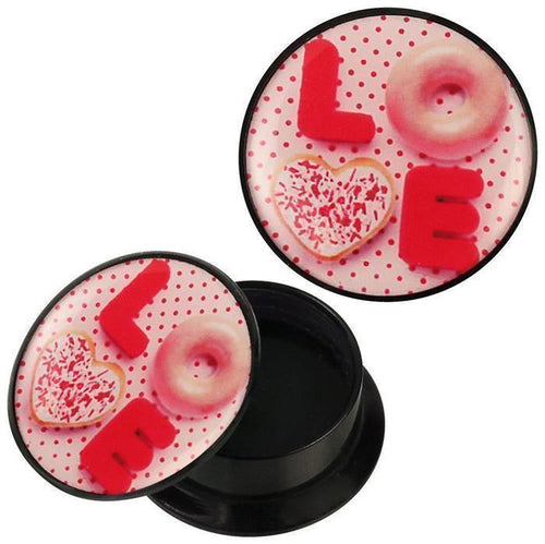 A round black Schraub Plug Acryl rosa LOVE Donut Herz Keks Punkte Piercing Ohrschmuck features a lid with cookies and candy spelling LOVE on a pink polka dot background, with a pink donut O, heart-shaped cookie V, and red L and E candies.