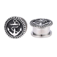 Load image into Gallery viewer, The Schraubplug Tunnel Edelstahl Plug features black and silver anchor designs with a beaded border on each metal piece—ideal for fans of stylish anchor-themed plugs. Displayed against a white background.
