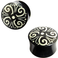 Cargar imagen en el visor de la galería, Two black Horn Plug schwarz weiße Spiralen, handgeschnitzt Tribal Buffalo Tunnel schwarz weiß, each hand-carved with white symmetrical spiral and dot designs on top, shown from side and top views.
