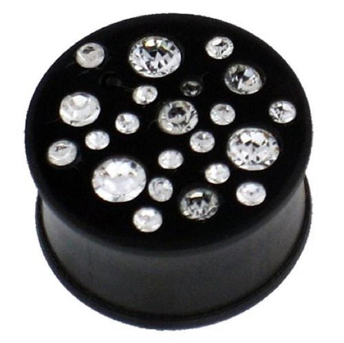 A black, hand-carved ironwood tribal plug tunnel expander featuring variously sized clear crystals on top.
