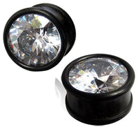 Load image into Gallery viewer, A pair of hand-carved Kristallplug Eisenholz schwarz Holzplugs with large, round, clear rhinestone fronts that sparkle and reflect light.
