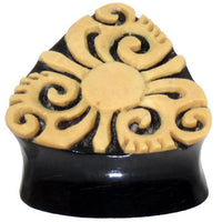 Load image into Gallery viewer, A black triangular Horn Plug Bio Kokos Schale Dreieck Tunnel with beige tribal floral and swirl carvings—an organic expander perfect as a unique earring or piercing inspired by Tribal Muster.

