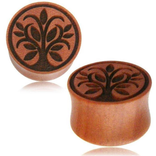 Two round, brown Holz Plug Sawoholz Tunnel Expanders, hand-carved with a Baum des Lebens design of stylized leaves and branches; one stands upright, the other lies on its side, showing both the intricate engraving and shape.