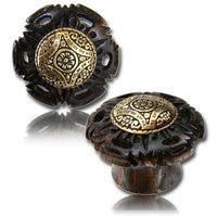 Cargar imagen en el visor de la galería, Two ornate Tamarinden Holz Plug drawer knobs in dark wood with antique golden brass inlay, featuring rhombus and floral tribal patterns—one shown from the front, the other from the side.
