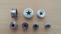 Load image into Gallery viewer, Seven Edelstahl Tunnel Plug Schraubplug Stern schwarz silber Scheibe ribbed Piercings with black star designs are arranged by size on a light wooden surface in two rows, from largest to smallest.
