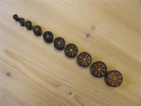 Load image into Gallery viewer, Ten round Arangholz tokens, resembling the Plug Arangholz Wikinger Kompass Inlay double flared, display Norse runes from smallest to largest in a diagonal line on a light wood surface, evoking a Viking compass design.
