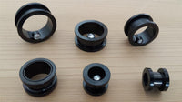 Load image into Gallery viewer, Sechs Edelstahl Flesh Tunnel ribbed Plug schwarz mit Glitzer Zirkonia Stein Schraubplug sind auf einer hellen Holzfläche angeordnet. Jeder Plug hat eine glänzende Schraube und überzeugt durch sein modernes Design.
