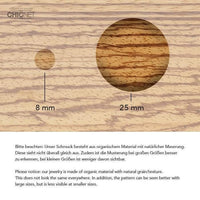 Load image into Gallery viewer, Two wooden circles (8 mm &amp; 25 mm) on an organic background show how size affects wood grain visibility. Bilingual text explains this for the Holz Plug Tunnel Kokosholz Resin Paua Abalone Kreise schillernd Tribal Expander style.
