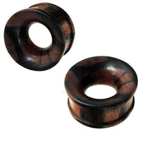 Cargar imagen en el visor de la galería, Two round, dark brown Holztunnel Tigerholz ear gauges with natural grain, domed shape, flared edges, and hand-carved tribal design, shown polished on a white background.
