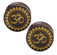 Load image into Gallery viewer, A pair of hand-carved Tamarind wood plugs, each featuring a gold-painted Om symbol with a laser-engraved floral design, crafted in a tribal organic style.

