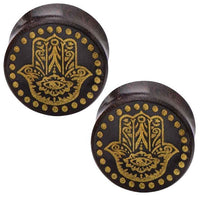 Load image into Gallery viewer, These round, dark brown Holz Plugs are crafted from Tamarind wood and feature gold-painted Khamsa (Hand of Fatima) designs with dotted borders, as described in the Holz Plug Poor Mans Hand Tamarind Khamsa Punkte gold Tunnel.
