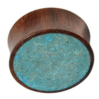 Load image into Gallery viewer, The Holz Plug Sonoholz Crushed Türkis Inlay double flared features a flat, circular face with inlaid crushed Türkis and a textured, speckled surface for a unique tribal expander look.
