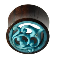 Cargar imagen en el visor de la galería, The Tunnel Sonoholz Resin Türkis Inlay Spiralbögen is a cylindrical wooden ear gauge featuring a circular opening with a decorative blue swirl Türkis inlay at the center.
