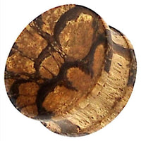 Load image into Gallery viewer, A close-up view of the Tribal Tigerholz konkav Maserung Holz Plug, a hand-carved brown ribbed wood plug with unique grain patterns resembling tree rings or natural textures.
