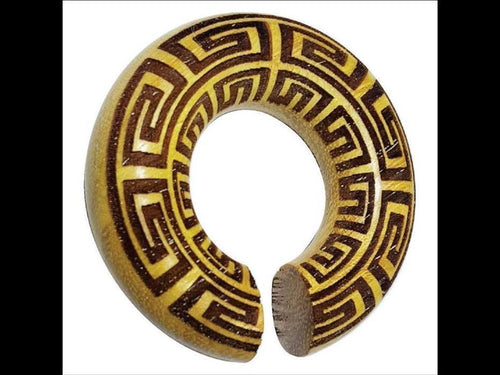 The Ohr Donut Piercing griechisch Jackfrucht Holz is a round, hollow wooden bangle with a small opening, adorned with a yellow and brown Greek key pattern, displayed against a white background and resembling an elegant donut accessory.