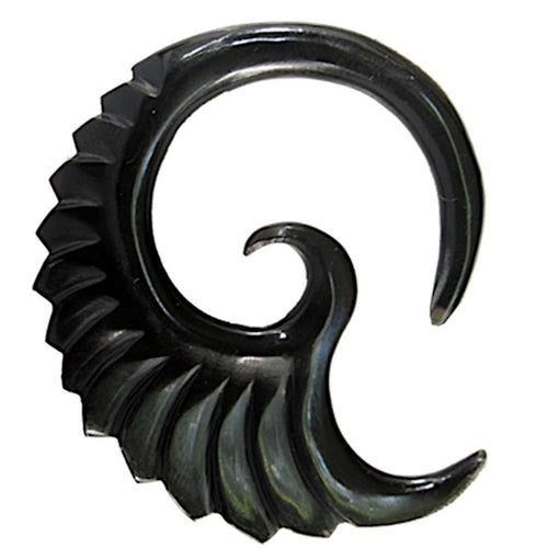 The Tribal Horn Piercing Expander Feder Spirale is crafted from black buffalo horn and features a spiral shape with a smooth inner curve and ridged, wing-like outer edge, echoing the look of a stylized feather or seashell.