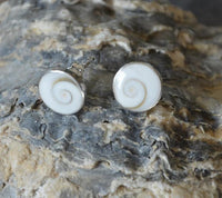 Load image into Gallery viewer, Round Shiva Auge stud earrings (6mm/10mm/12mm) in 925 silver are shown on a textured gray and beige rock.
