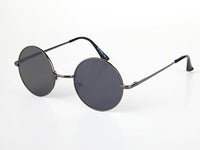 Cargar imagen en el visor de la galería, The Sonnenbrille Unisex Rund Hippie Brille John Lennon 400UV features round black sunglasses with thin metal frames and dark lenses, inspired by the iconic John Lennon style, displayed on a white surface.
