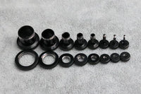 Load image into Gallery viewer, A row of Metalltunnel Tunnel Chirurgenstahl Unisex Edelstahl Plug schwarz Rand Expander Piercing components—rings, cylinders, threaded fittings—are arranged in descending order on a light gray textured surface.
