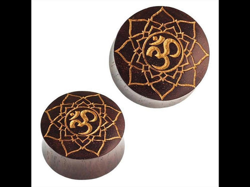 Two round, dark brown "Holz Plug Sternblume OM" Sonoholz plugs with golden mandala and Om engravings are displayed against a white background.
