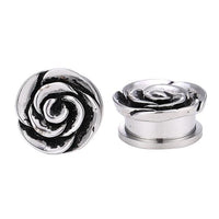 Cargar imagen en el visor de la galería, Two silver Plug Schraubplug Edelstahl ear pieces shaped like large ribbed rose blossoms, featuring detailed swirling petal designs—ideal for your lobe piercing. One stands upright, the other lies on its side.
