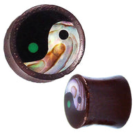 Cargar imagen en el visor de la galería, The Sonoholz Plug Yin Yang Inlay Paua Abalone Resin schwarz is a cylindrical black tunnel expander featuring a tribal Yin Yang inlay with iridescent abalone and a green dot, shown from the front and angled views.
