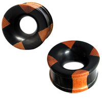 Load image into Gallery viewer, Hand-carved Holztunnel plugs made of black Eisenholz and brown Teakholz with a cross pattern, hollow center, and flared edges—a bold Tribal Holz Tunnel design.
