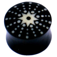Cargar imagen en el visor de la galería, The Horn Plug schwarz weiß Stern Punkte handgeschnitzt is a black, double-flared, hand-carved buffalo horn plug featuring a white star and dot design radiating from the center on its flat end.
