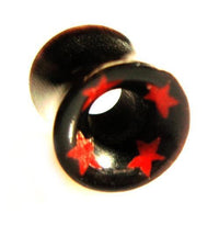 Cargar imagen en el visor de la galería, A Tribal Horn Tunnel schwarz Horntunnel Plug with red stars around the rim, featuring a hollow center and front pattern, is shown in black organic material from an angled view.
