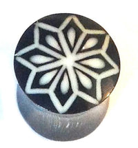 Cargar imagen en el visor de la galería, The Horn Plug Stern weiß is a black organic plug with an eight-pointed white geometric star pattern, gray metallic-like sides, perfect for tribal tunnel expanders and unisex piercing jewelry.
