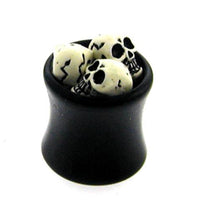 Cargar imagen en el visor de la galería, A small black cauldron filled with miniature cracked skulls, perfect for displaying your Plug Totenköpfe Tunnel Ohrstecker Ohrring Expander Dehner Piercing Ohrschmuck Unisex schwarz weiß against a white background.
