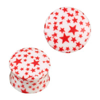 Load image into Gallery viewer, Zwei gewölbte Acryl Plugs in Weiß mit roten Sternen aus der Serie &quot;Plug Acryl weiß mit roten Sternen gewölbt Piercing Ohrschmuck&quot; in verschiedenen Größen – einer stehend mit sichtbarem Muster, der andere liegend für optimale Formansicht.

