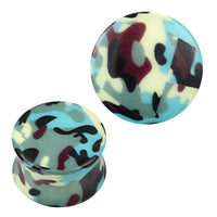 Cargar imagen en el visor de la galería, Two acrylic plugs with a green, blue, yellow, purple, and black camouflage pattern. The Plug Acryl Camouflage Muster is perfect piercing jewelry for those who love bold ear accessories; one plug stands upright while the other lies on its side.
