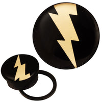 Load image into Gallery viewer, The Schraub Plug Tunnel Acryl schwarz weiß Blitz mehrzackig shows a black plug with a striking yellow lightning bolt; one plug is front-facing, and the other is angled to display the side and back design.
