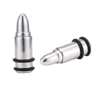 Load image into Gallery viewer, Two silberne Edelstahl Plugs in Patronenhülsenform aus Chirurgenstahl mit schwarzen Gummiringen—einer stehend, einer liegend—werden auf weißem Hintergrund gezeigt.
