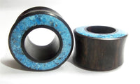 Cargar imagen en el visor de la galería, Two cylindrical Flesh Tunnel Eisenholz schwarz Rim Crushed Türkis Inlay ear plugs with flared edges and bright blue Türkis stone inlays are shown on a white background.
