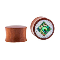 Cargar imagen en el visor de la galería, One Organic Sabaholz Plug features Paua Abalone Perlmutt inlay with a white ornate frame, while the other side shows the plain, hand-carved wood of the eckig gerahmt Perlmutt Tunnel Tribal Expander.
