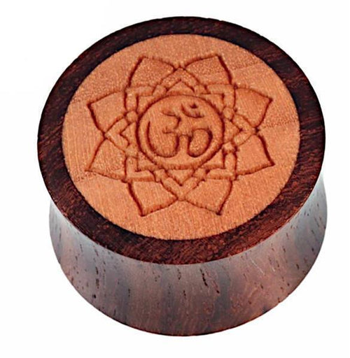 The "Holz Plug Om Blume Gravur zweifarbig handgeschnitzt braun" features a hand-carved Om flower design on a round, polished wood plug with an eye-catching two-tone brown finish.
