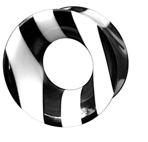The Bone HornTunnel weiß schwarz gestreift double flared is a round organic piece with a central hole, crafted from bone and Büffelhorn, featuring bold black and white stripes reminiscent of a Tribal Tunnel on a white background.