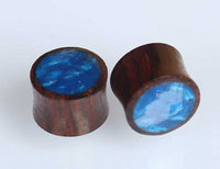 Load image into Gallery viewer, Two cylindrical Holz Plug Sonoholz blau schillernd Resin Inlay plugs with glossy blue resin on one end are shown on a white surface. These polished plugs are perfect as jewelry or decorative Tribal Holz Plugs for your accessory collection.
