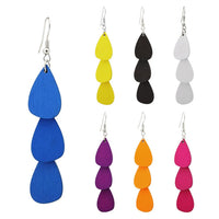 Cargar imagen en el visor de la galería, Seven pairs of bunte Holzohrringe “Tropfen lang” (68 mm) in vibrant colors—jeder Ohrhänger aus drei organischen Holzstücken, Edelstahlhaken, nickelfrei und angenehm zu tragen, im Tribal-Stil gestaltet.
